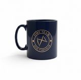 A glossy dark navy blue ceramic mug with a gold circular logo reading 'TIME TEAM' and 'NESS OF BRODGAR' around a ENGRAVED BUTTERFLY symbol, sitting on a white background.
